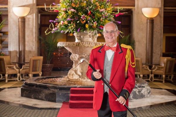 a man in a red suit holding a cane
