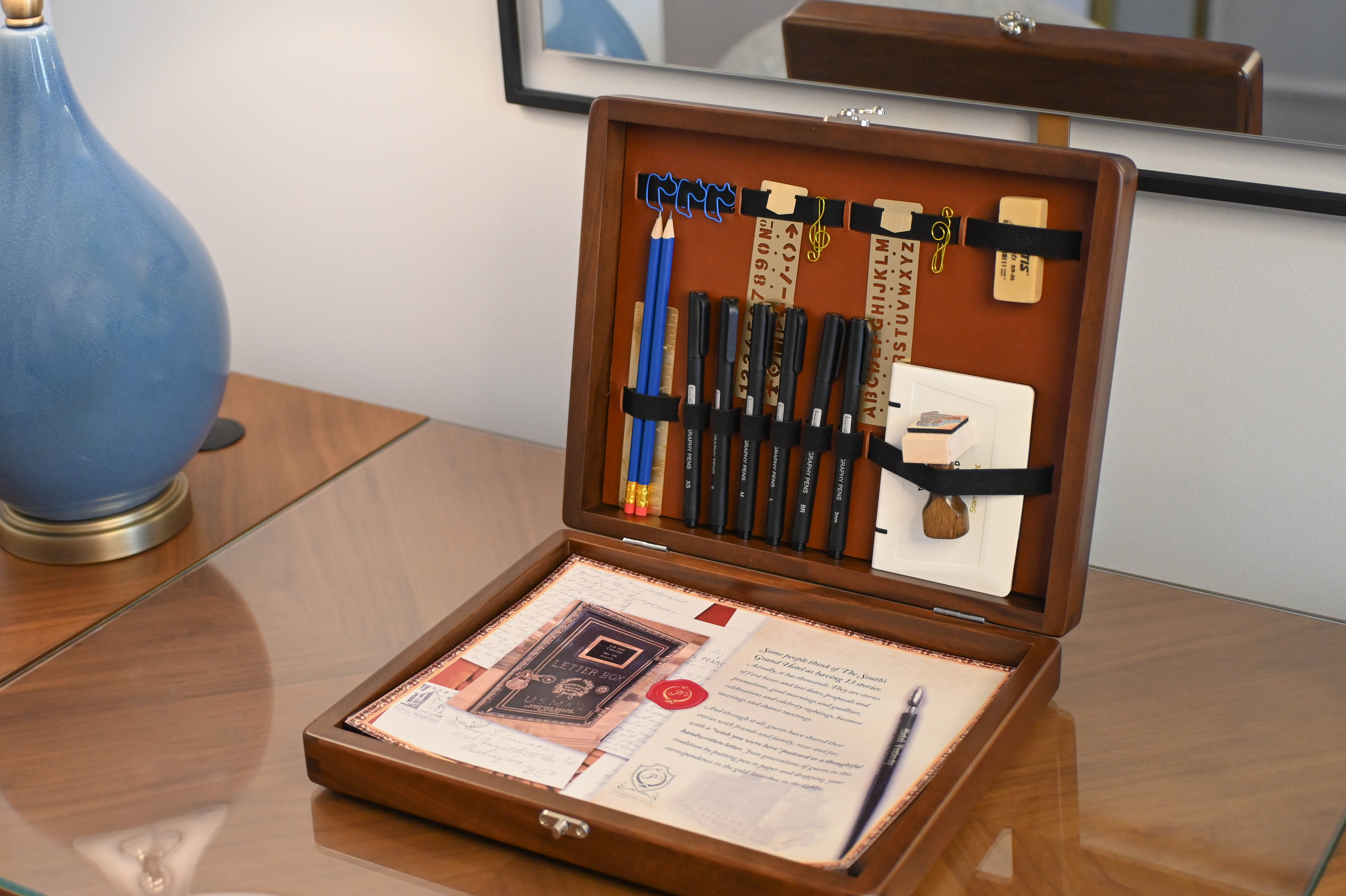 a wooden box with pens and a pen inside