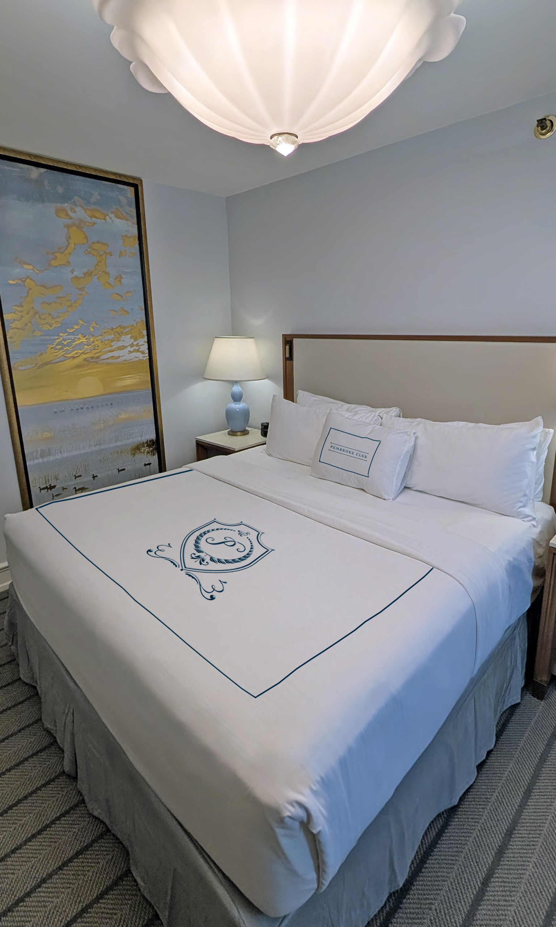 a bed with white sheets and pillows