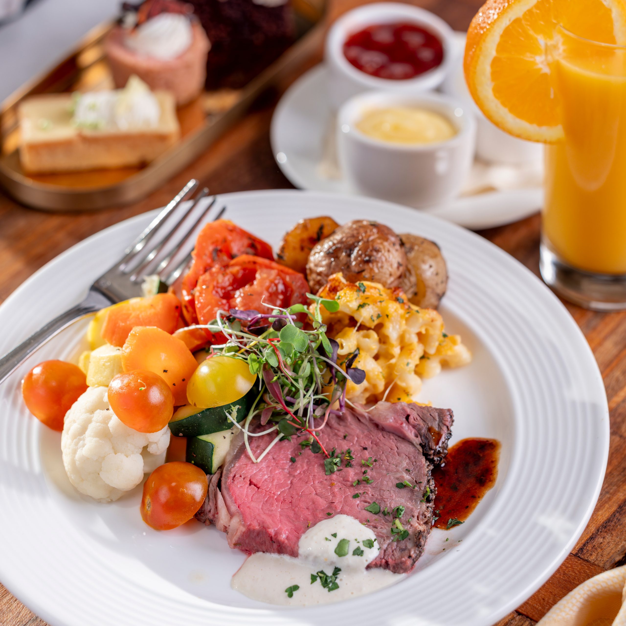 a plate of food with a glass of orange juice and a glass of juice