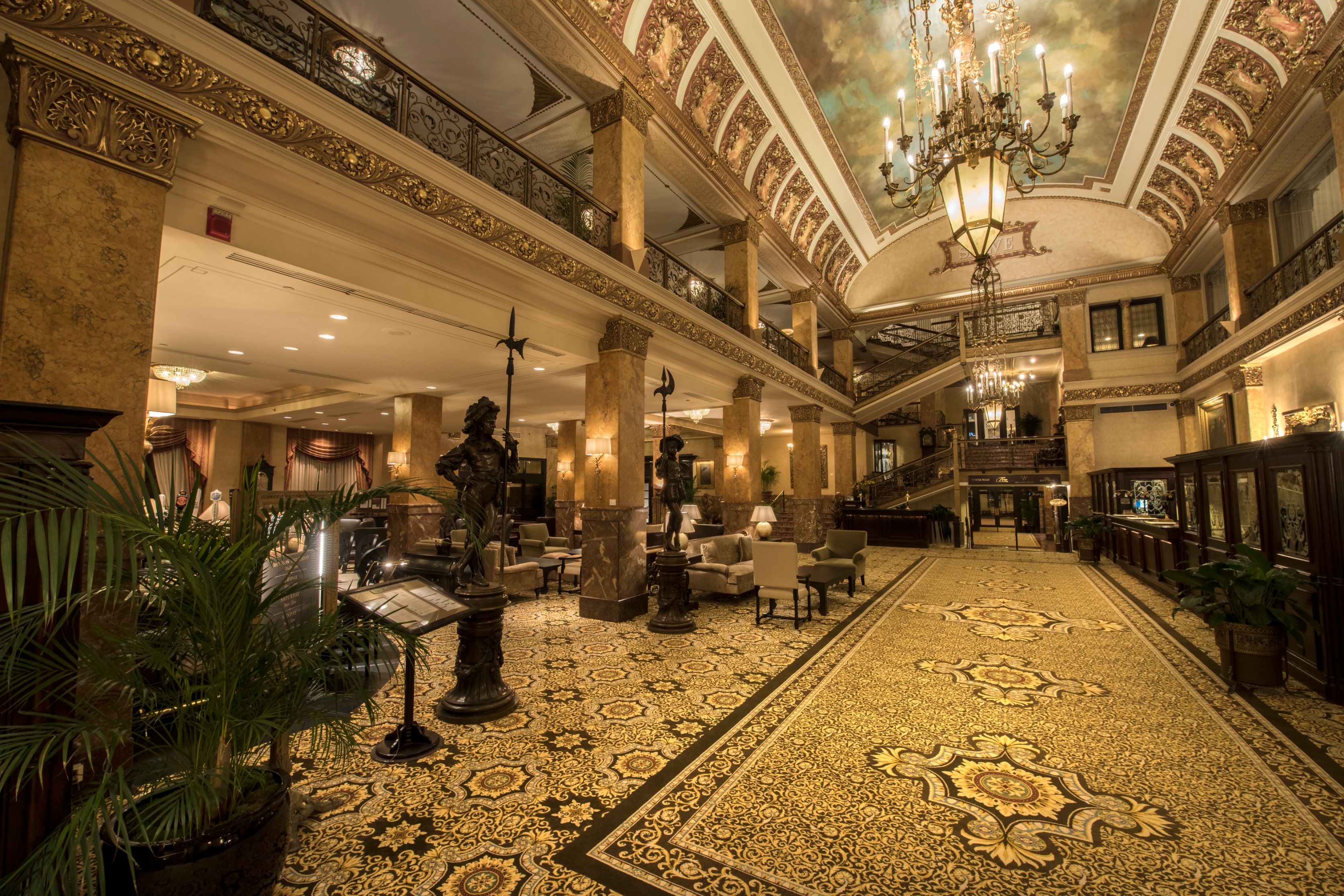 a large ornate room with a chandelier and a statue