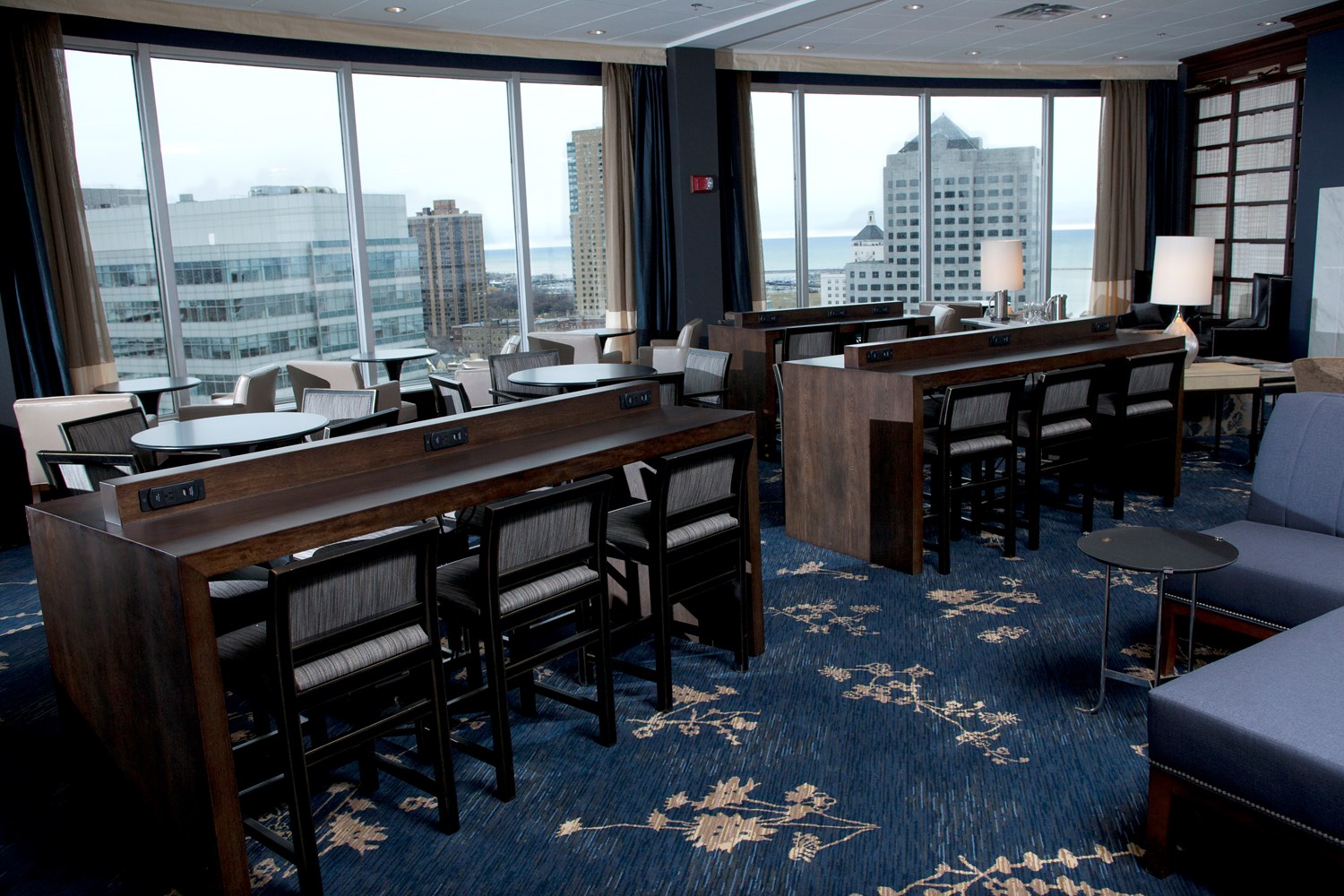 a room with tables and chairs and a view of a city
