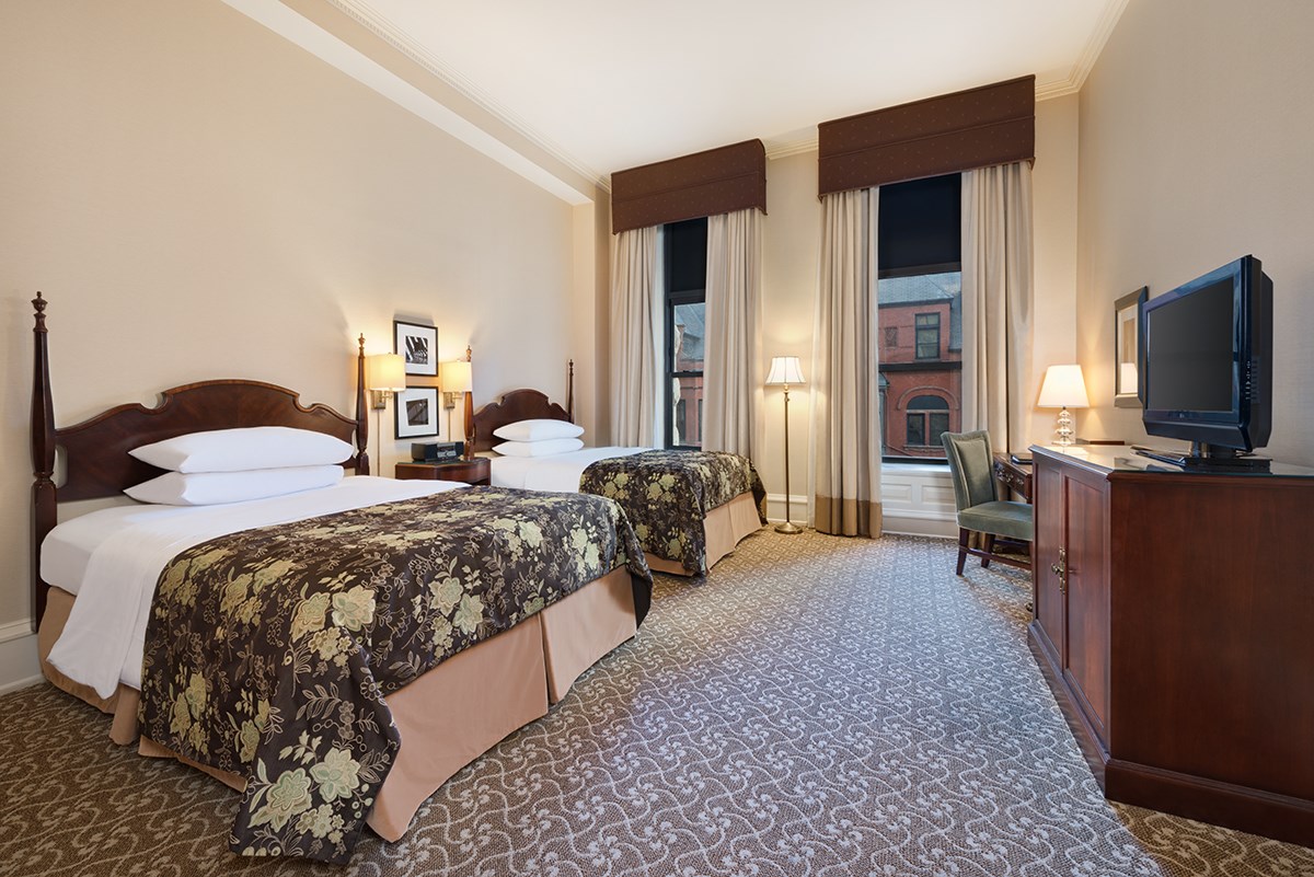a room with two beds and a desk