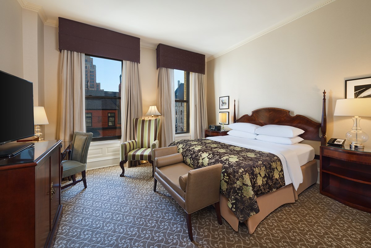 a room with a bed and chairs