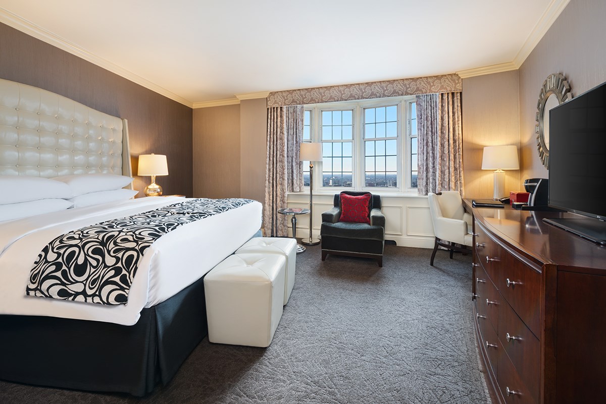 a bedroom with a large bed and a chair