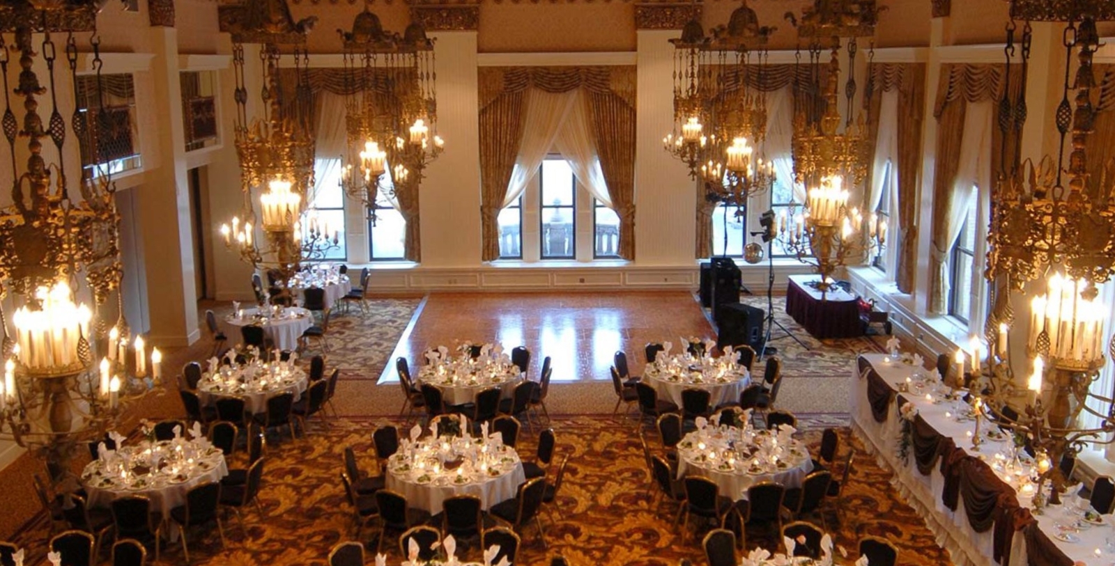 a large ballroom with tables and chandeliers