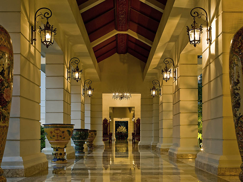 a hallway with columns and lamps