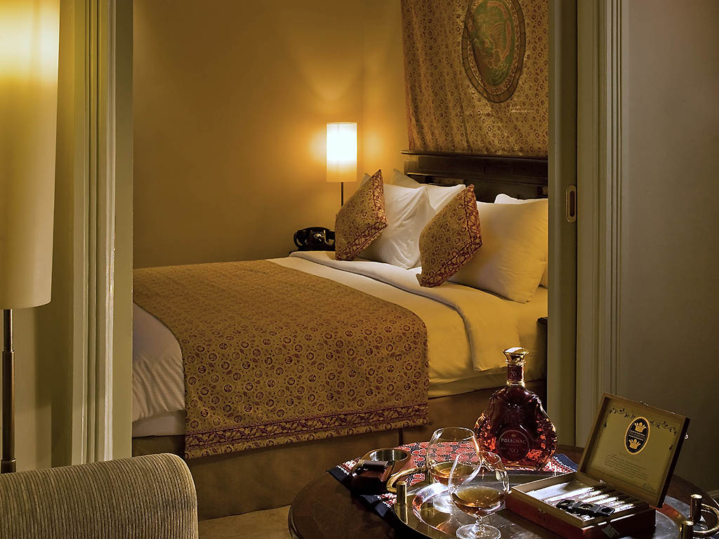 a bedroom with a bed and a tray of wine