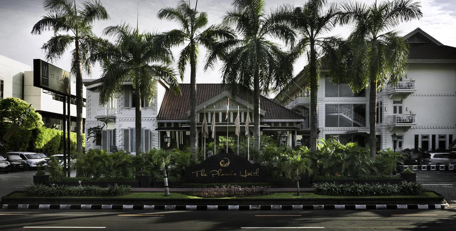 a building with palm trees and a sign