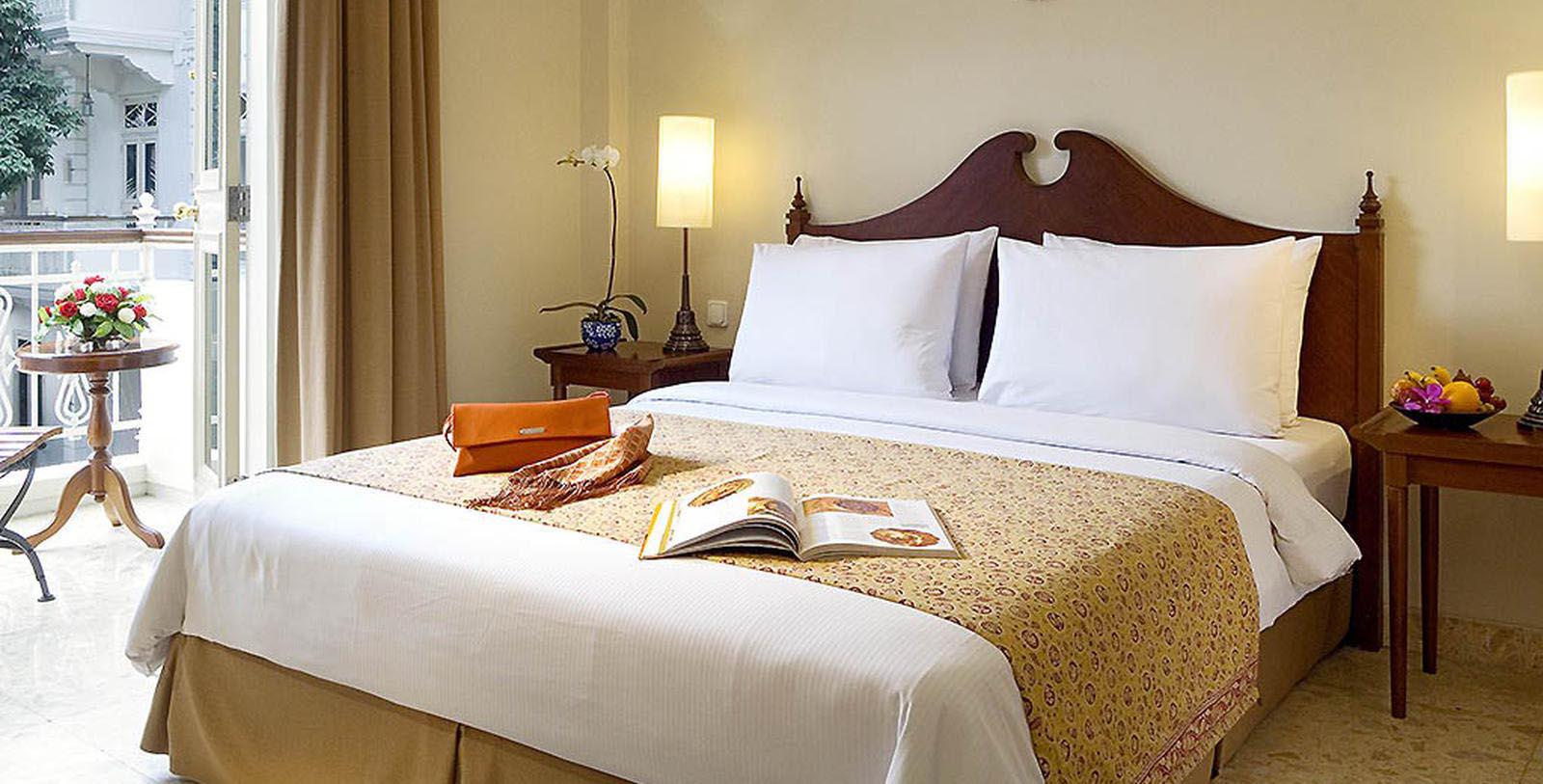 a bed with a book and a lamp