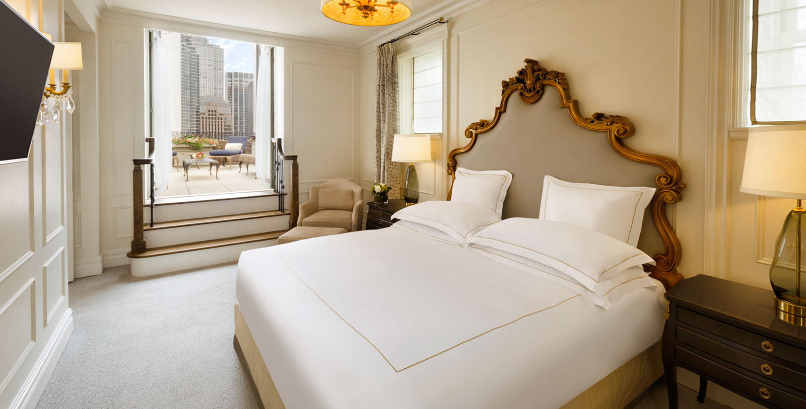 a bed with a large headboard and a lamp in a hotel room