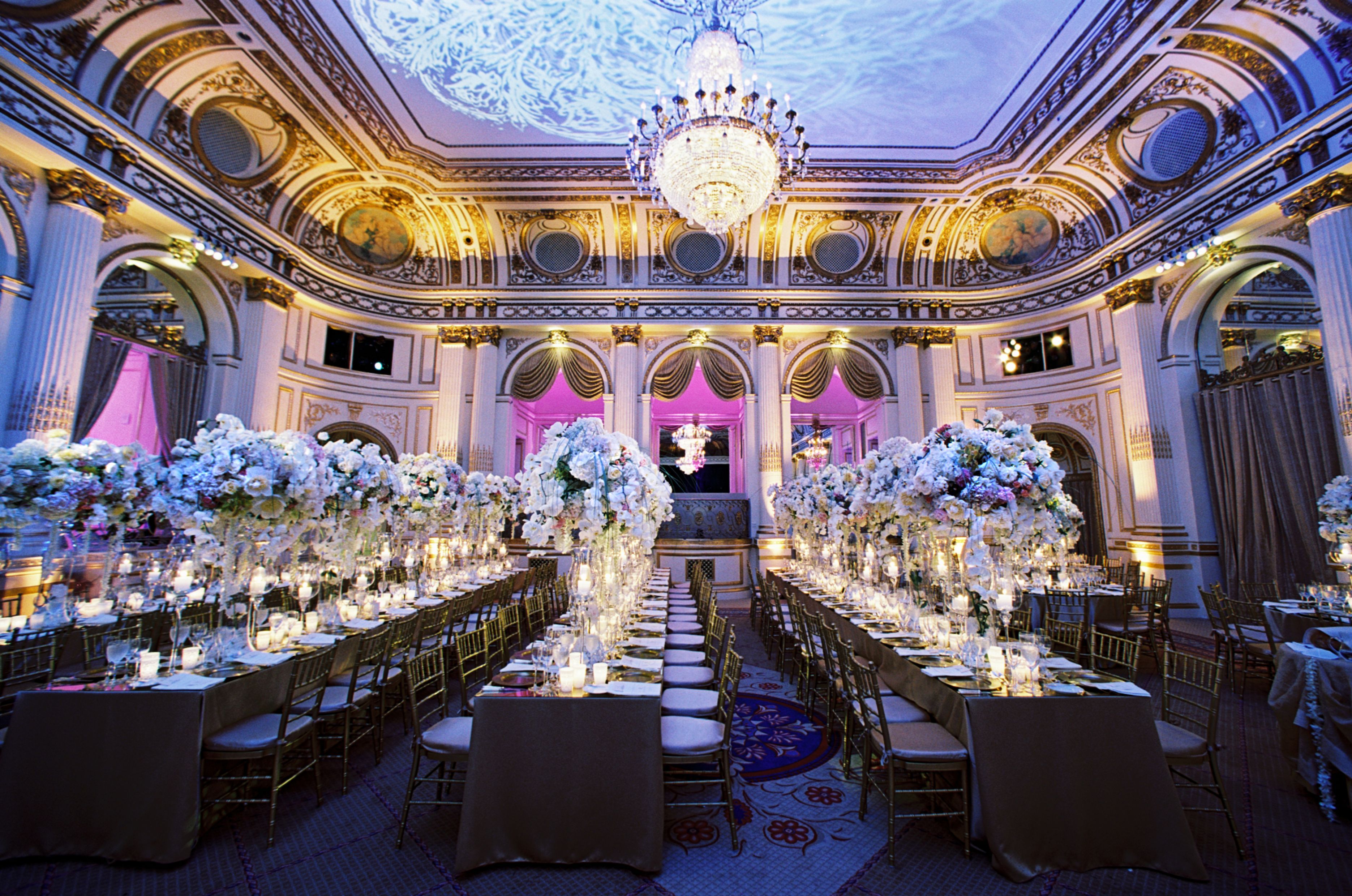 a room with tables and chairs and chandeliers