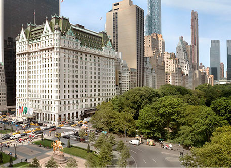 a large white building with green trees in front of it