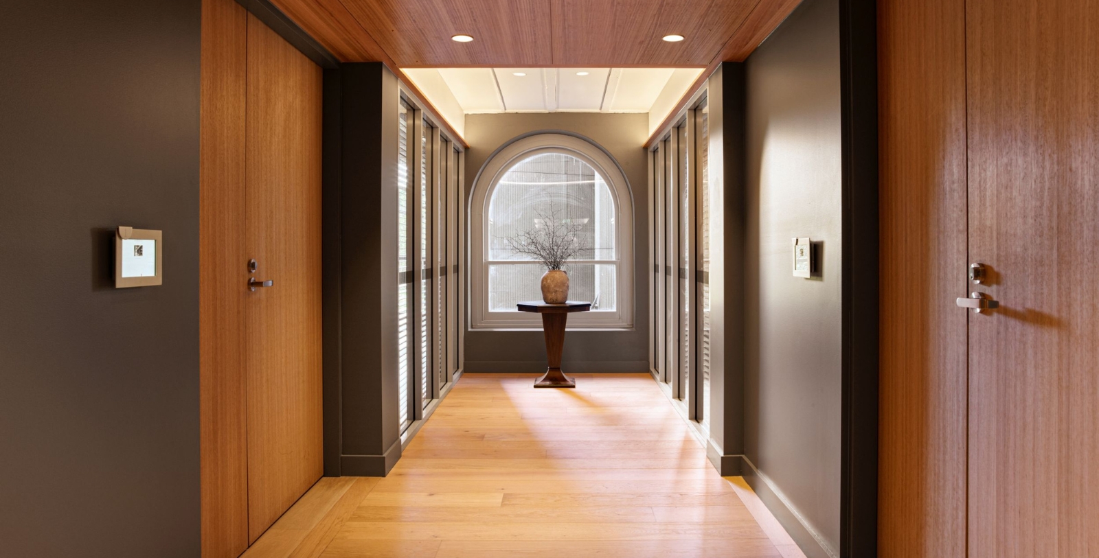 a hallway with a vase and a window