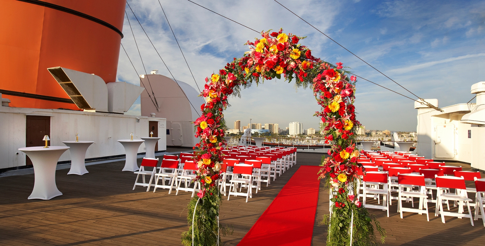 a wedding ceremony with red carpet and chairs