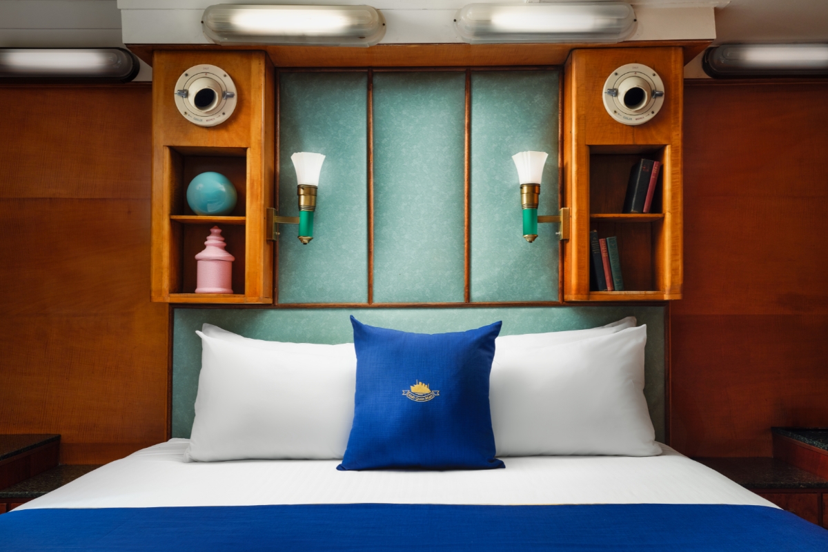 a bed with a blue pillow and a blue blanket