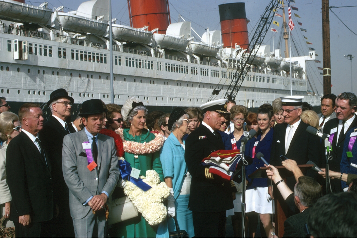a group of people standing in front of a large ship