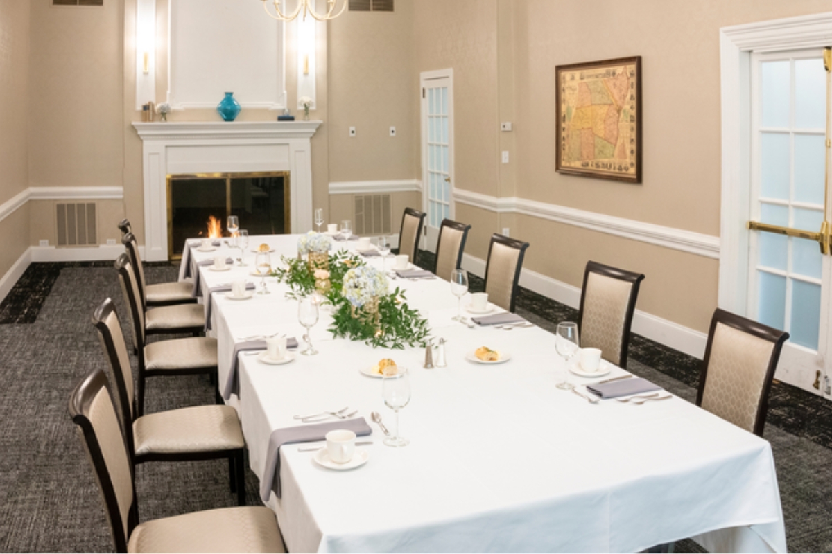 a long table with white tablecloths and plates and glasses