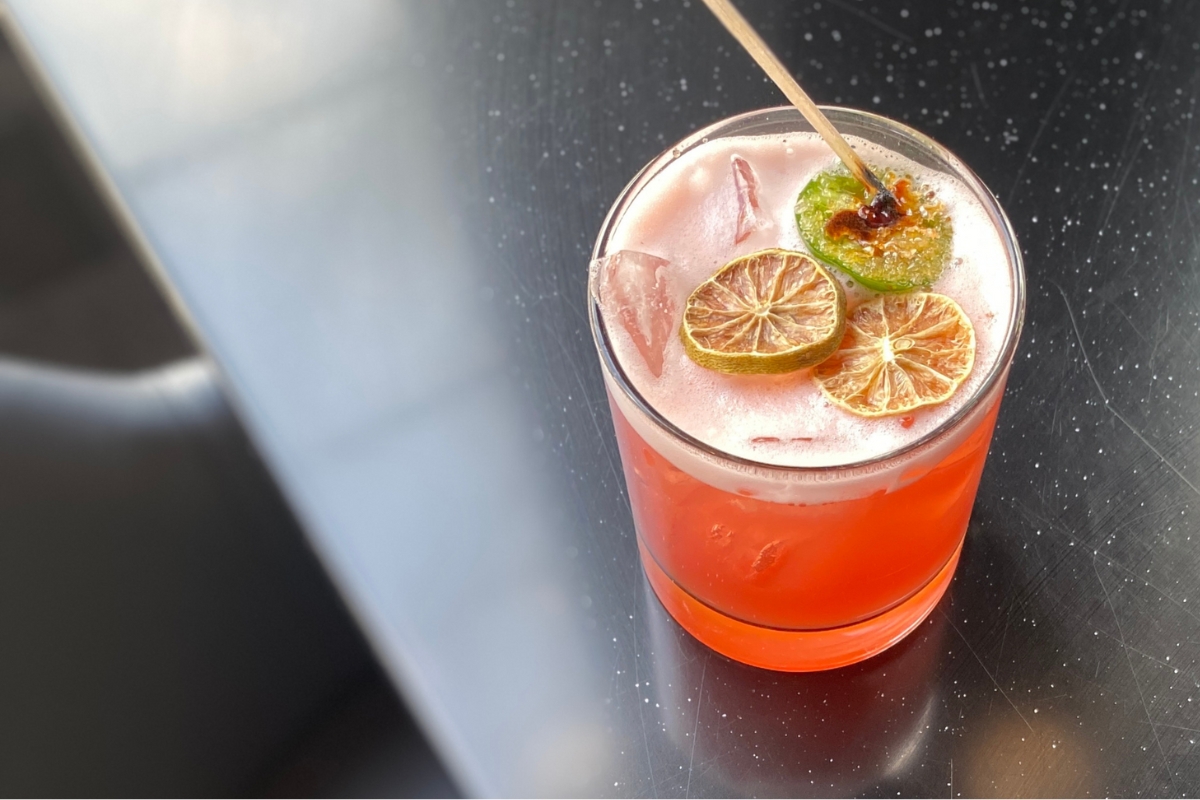 a drink with limes and a toothpick
