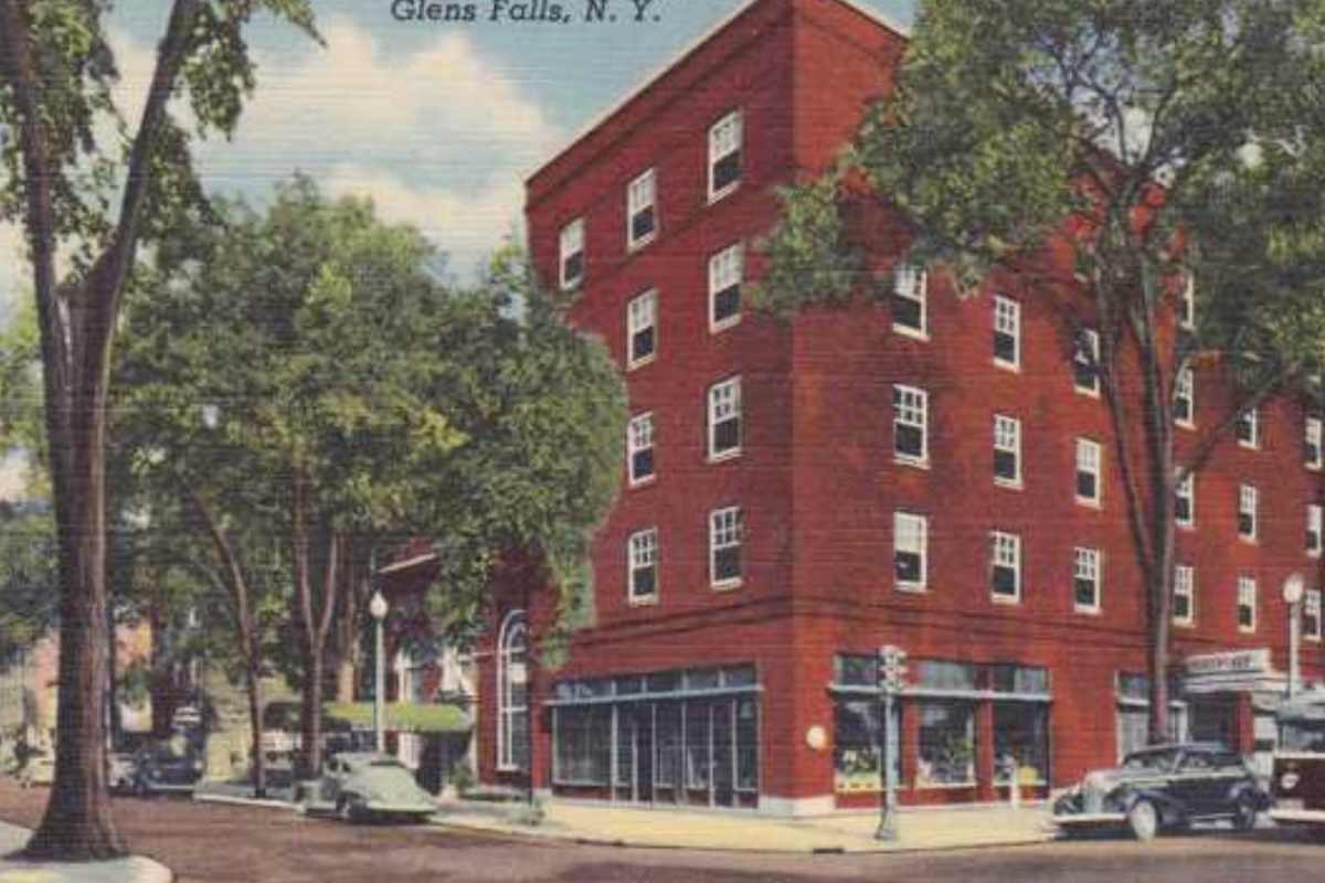 a red building with trees and cars