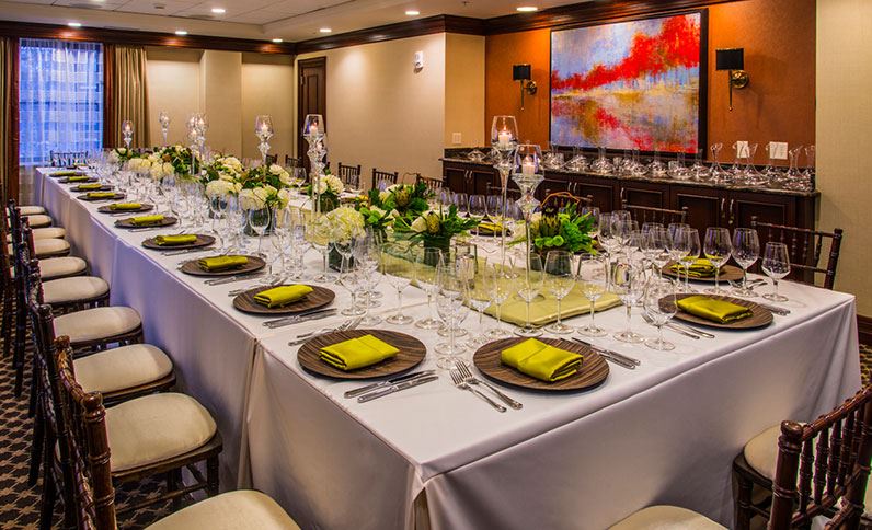a long table with white tablecloths and glasses