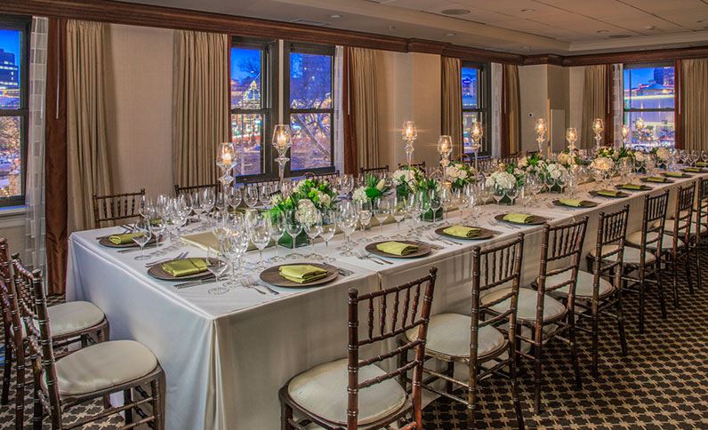 a long table with white tablecloth and wine glasses
