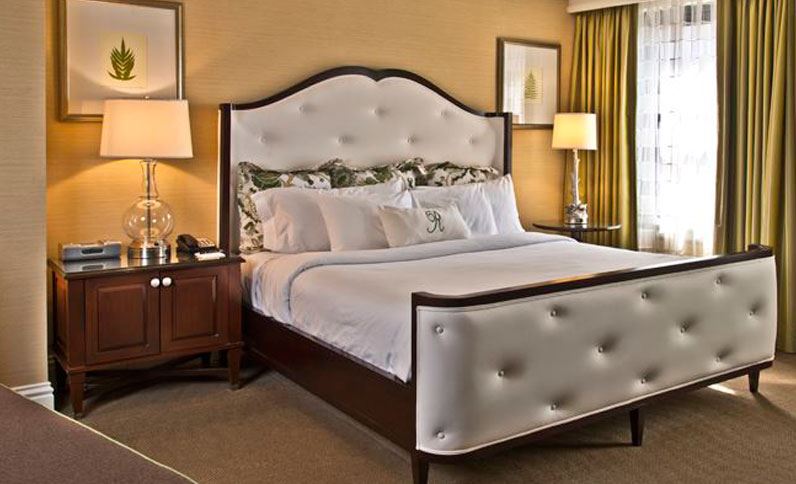 a bed with a white headboard and a lamp next to it