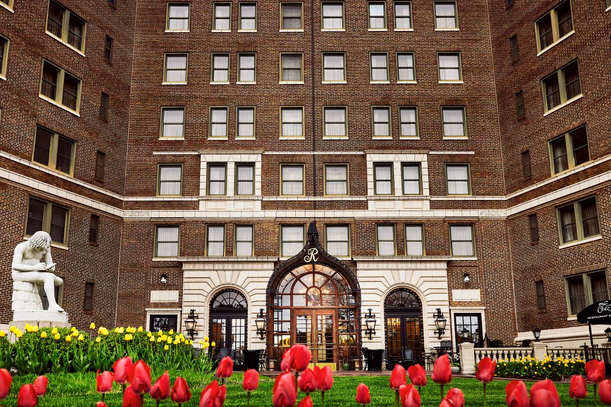 a building with many windows and a lawn with flowers