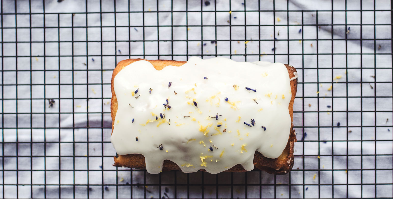 a loaf of bread with white frosting on a wire rack