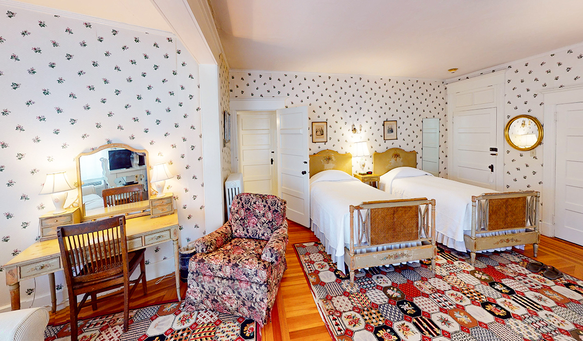 a room with two beds and a chair