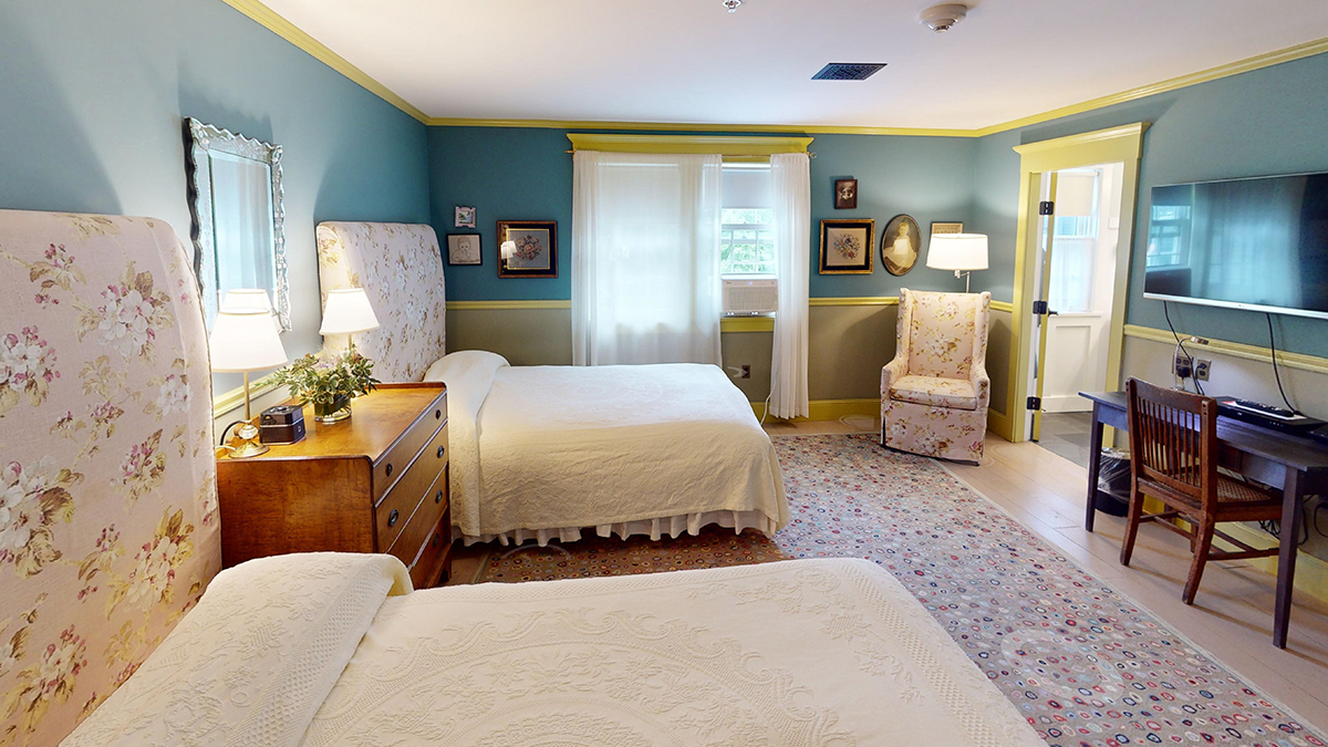 a bedroom with two beds and a dresser