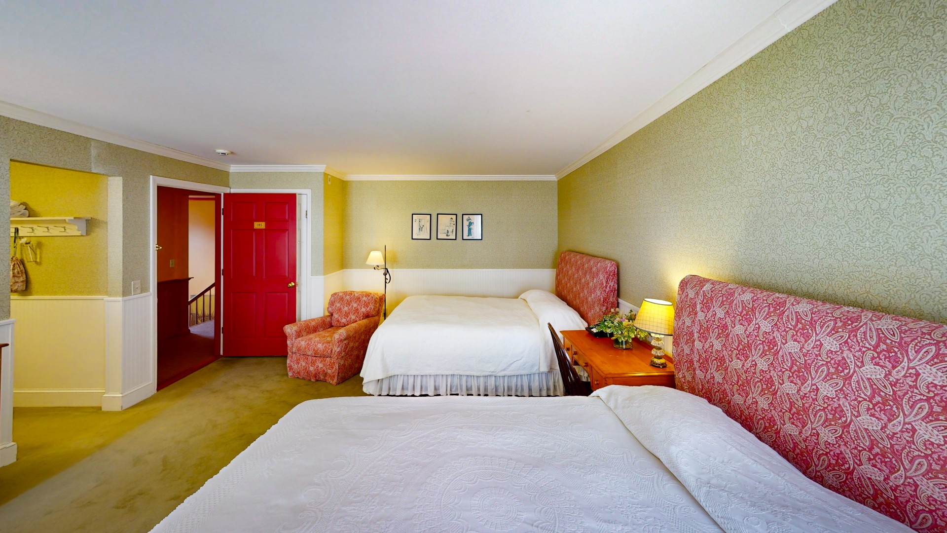 a room with two beds and a red door