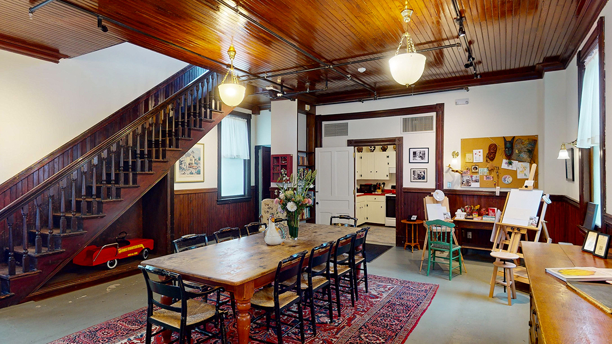 a dining table and chairs in a room with a staircase