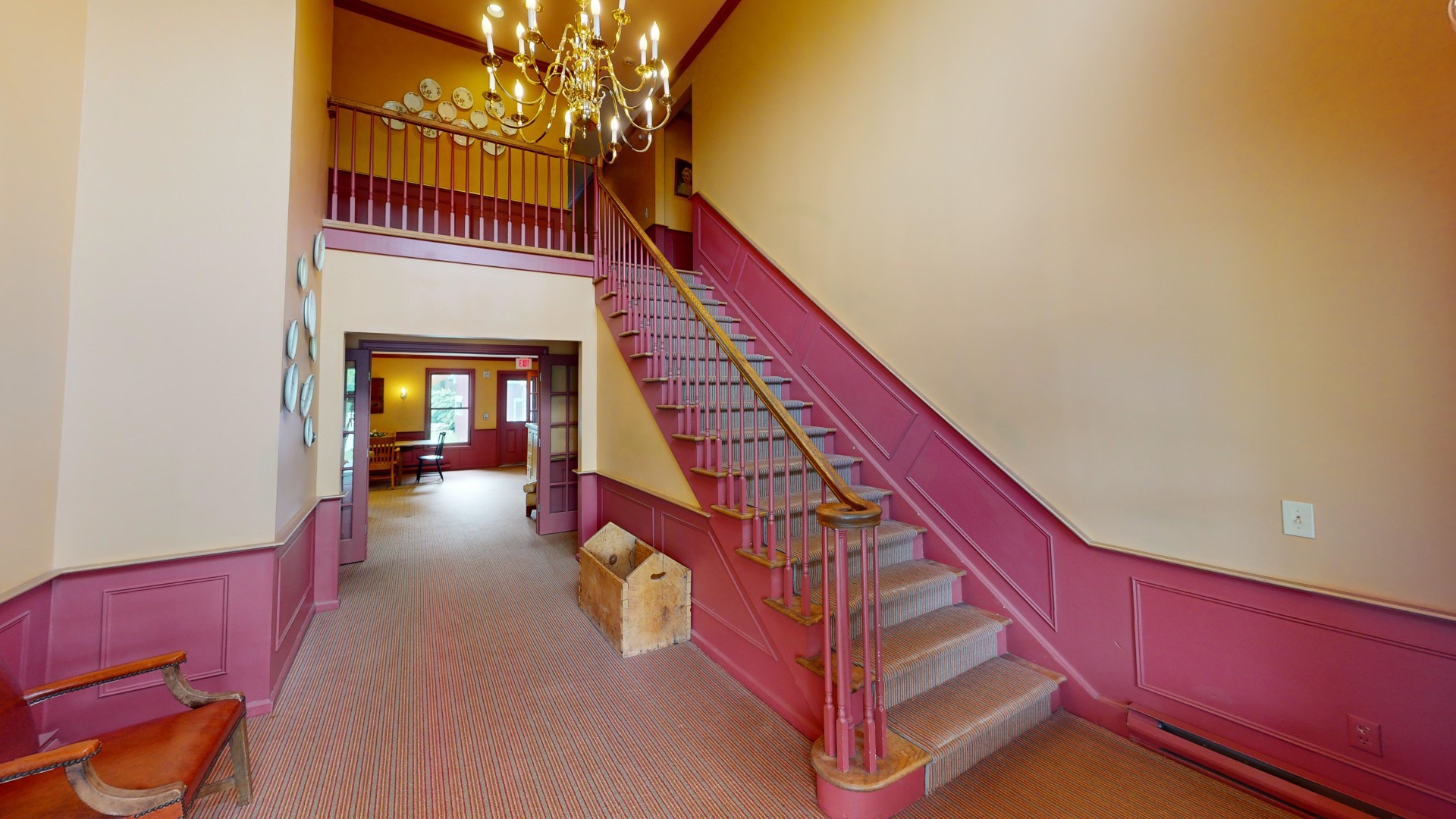 a staircase with pink railings and a chandelier
