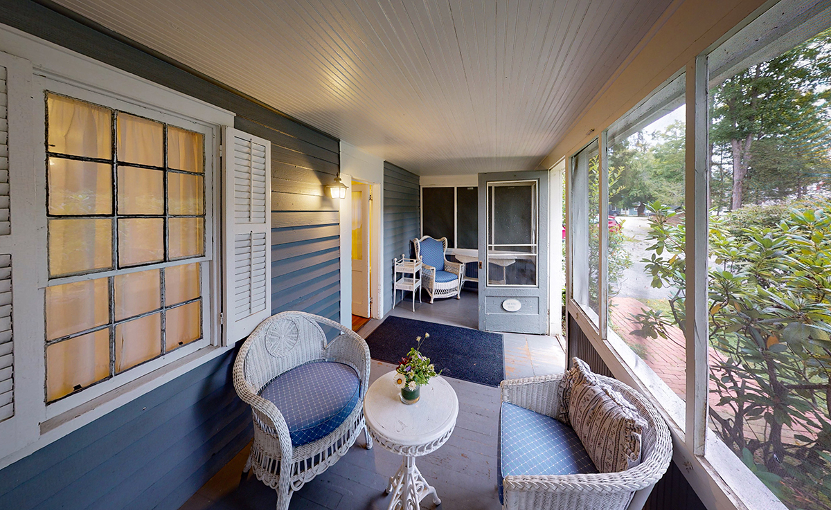 a porch with chairs and a table