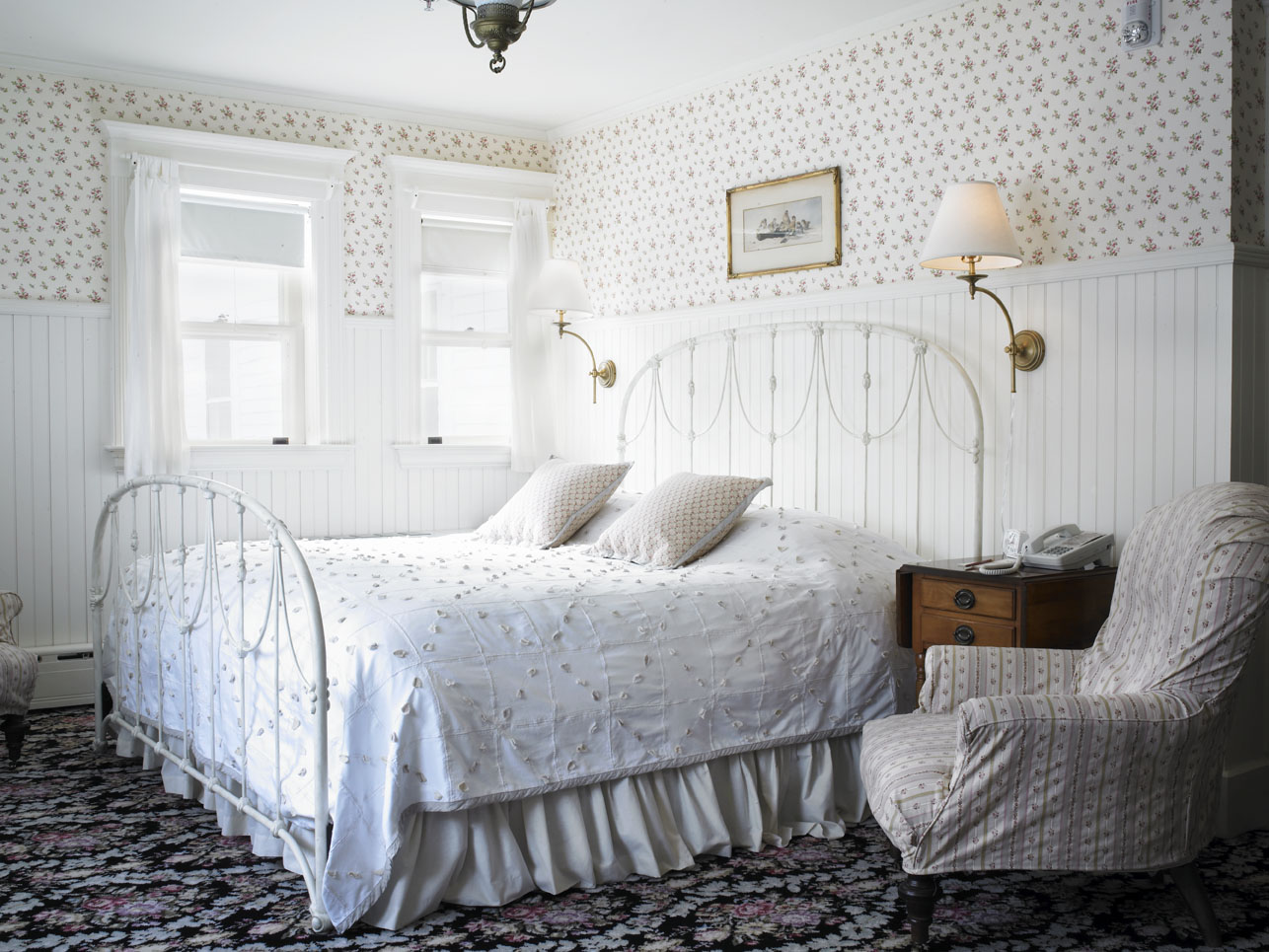 a bed with a white bedding and a chair in a room