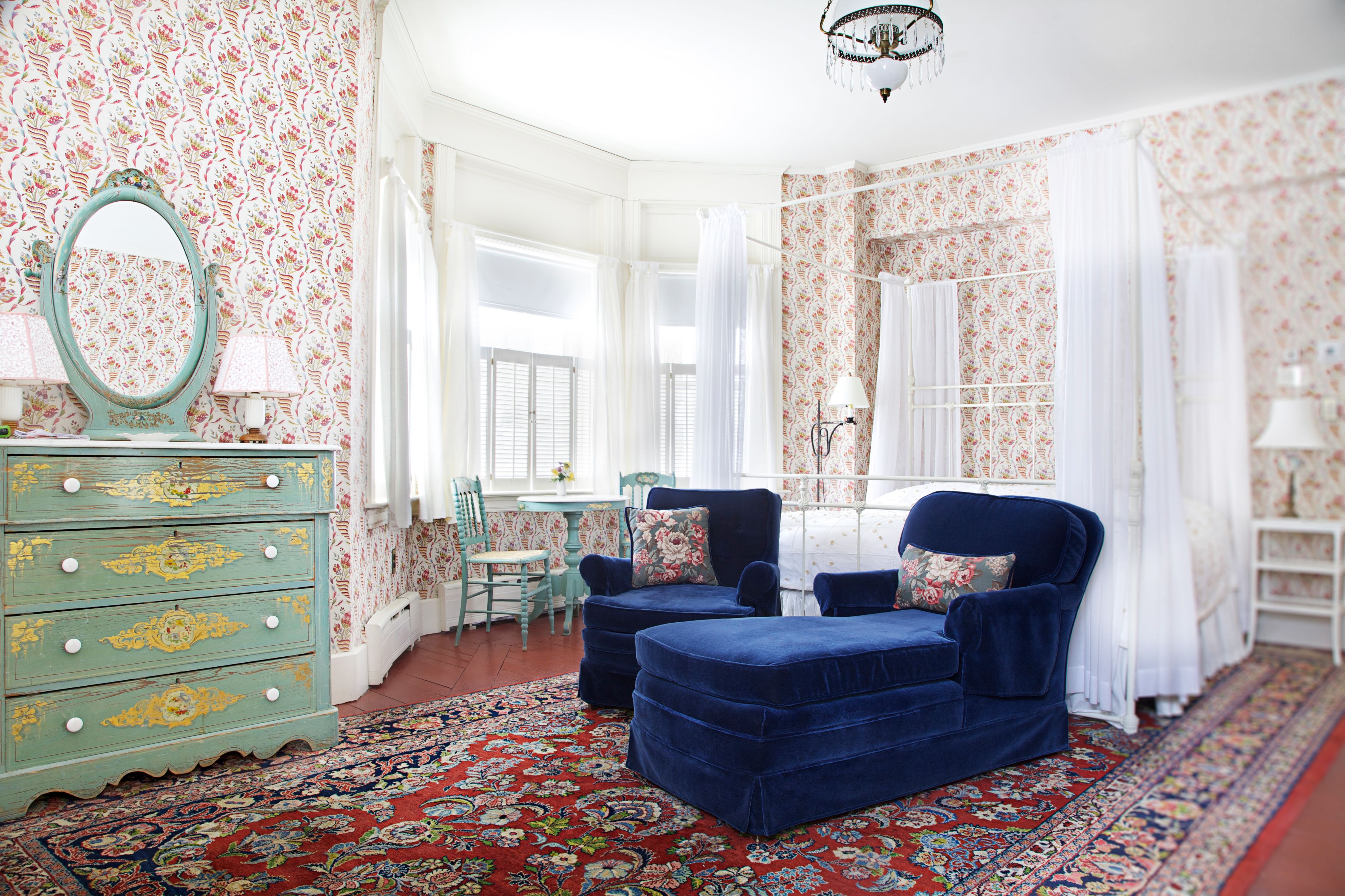 a room with a blue chair and a dresser