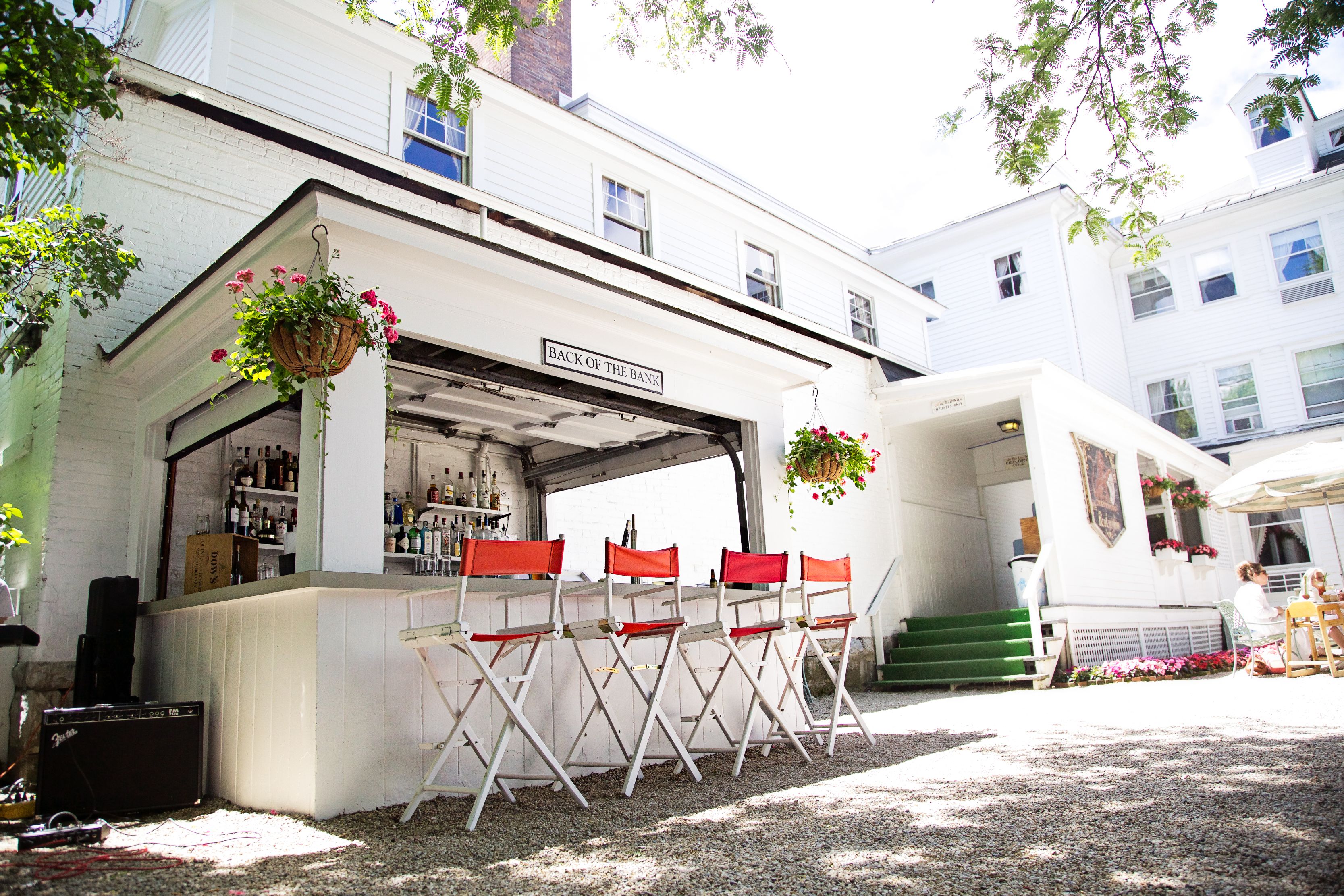a bar with chairs and a bar in front of a building