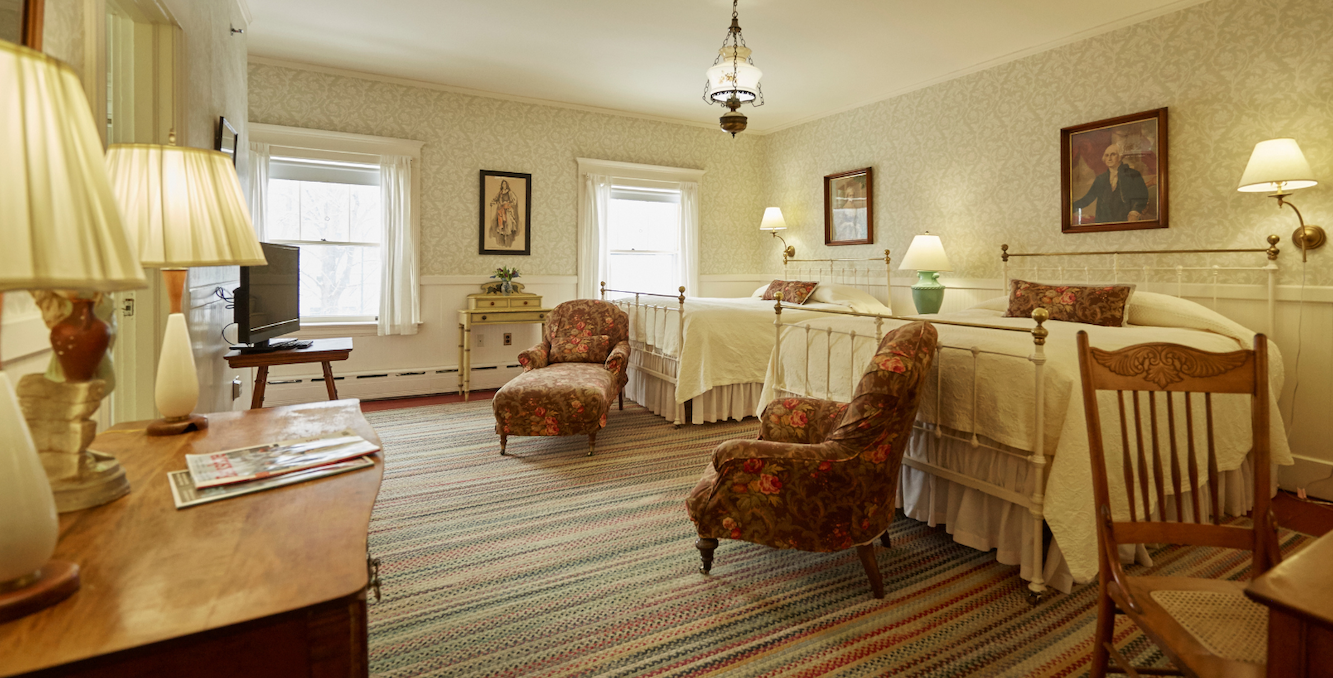 a room with a bed and chairs