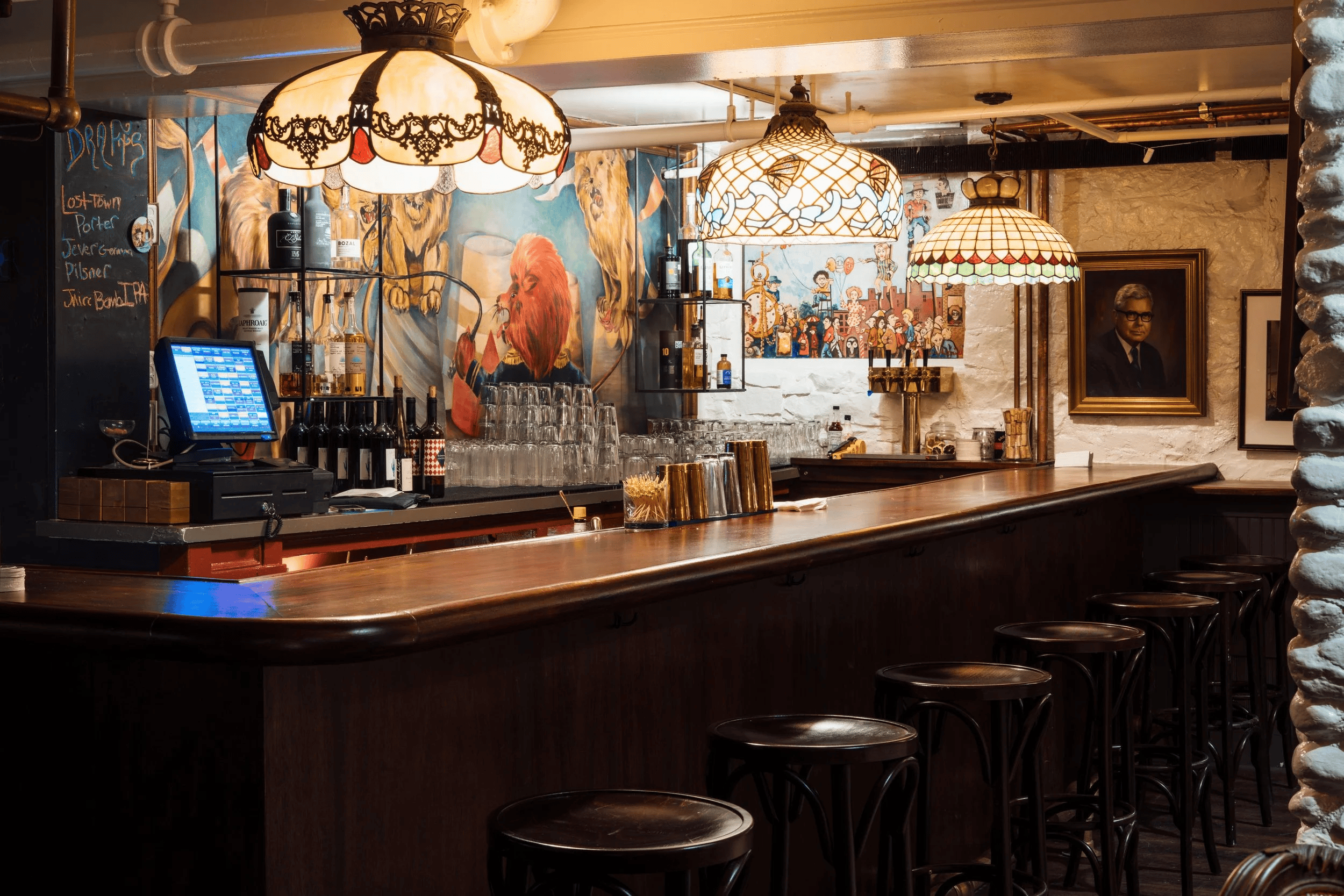 a bar with a row of stools and lights