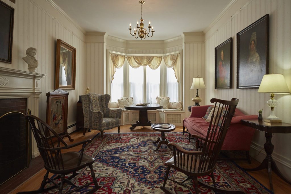 a room with a red couch and chairs