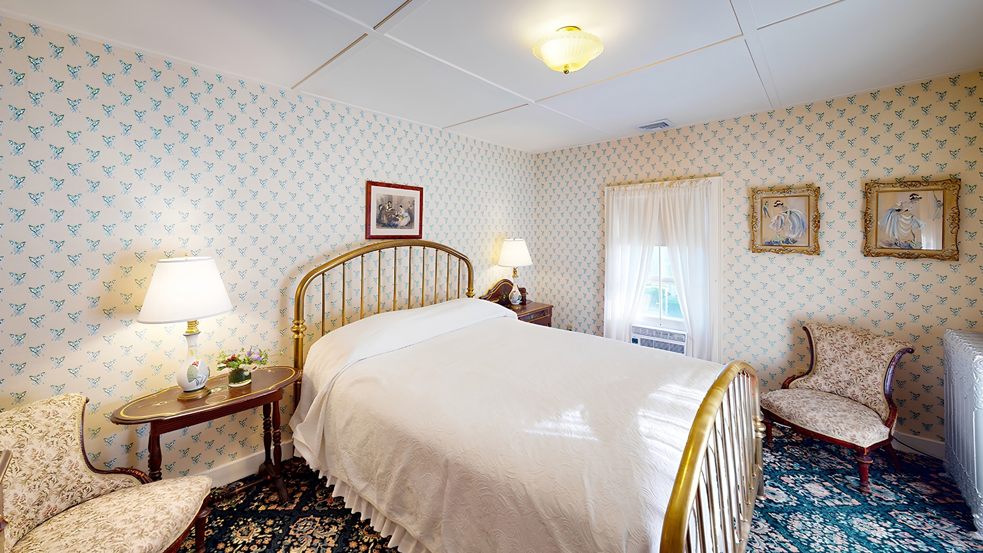 a bed with a gold headboard and a lamp on a table