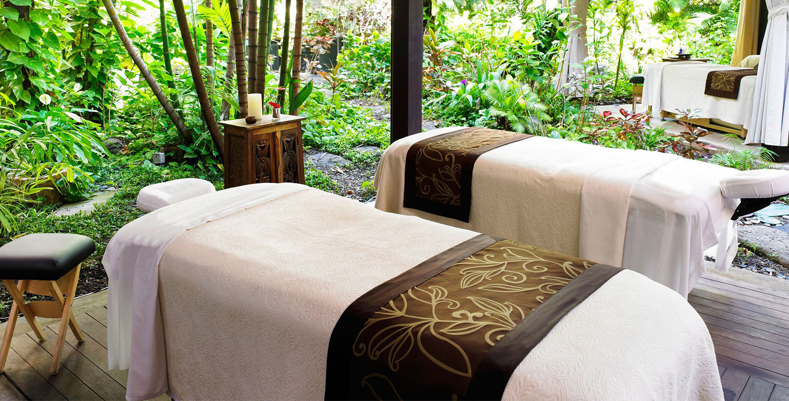 two beds with white blankets and brown trim