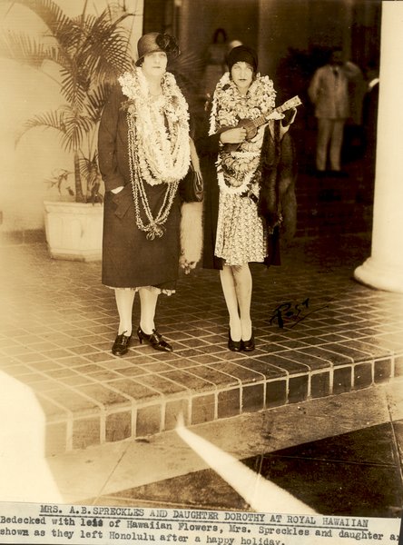 a couple of women wearing leis and a hat