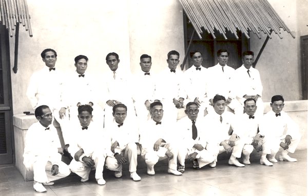 a group of men in white suits posing for a photo