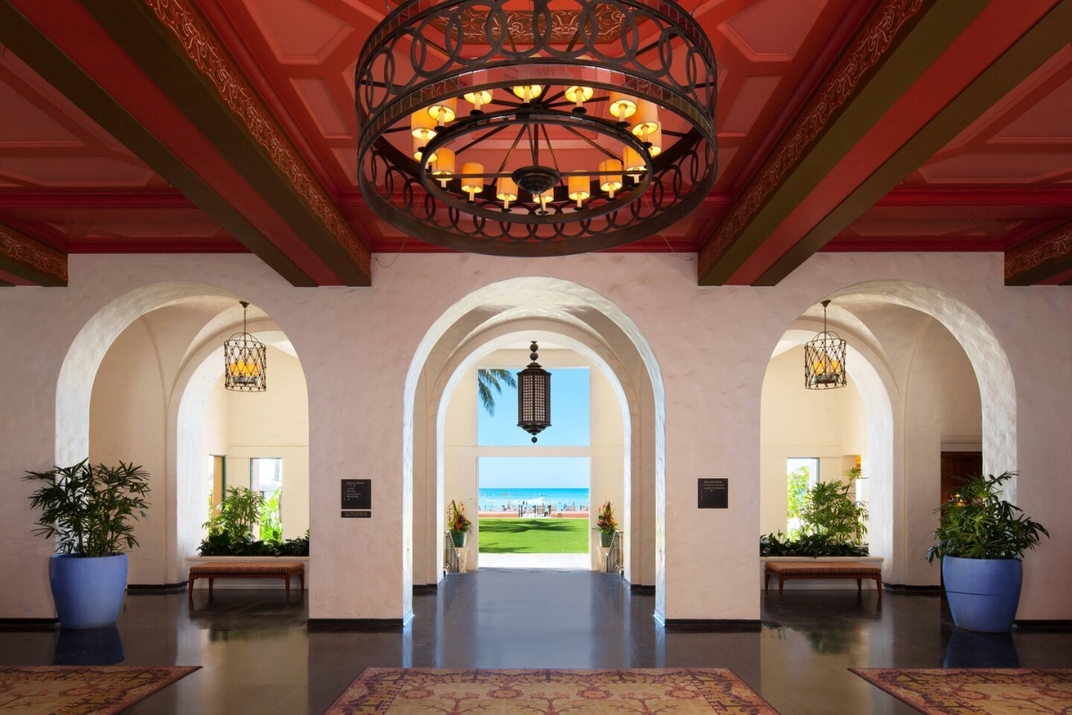 a hallway with a chandelier and a rug