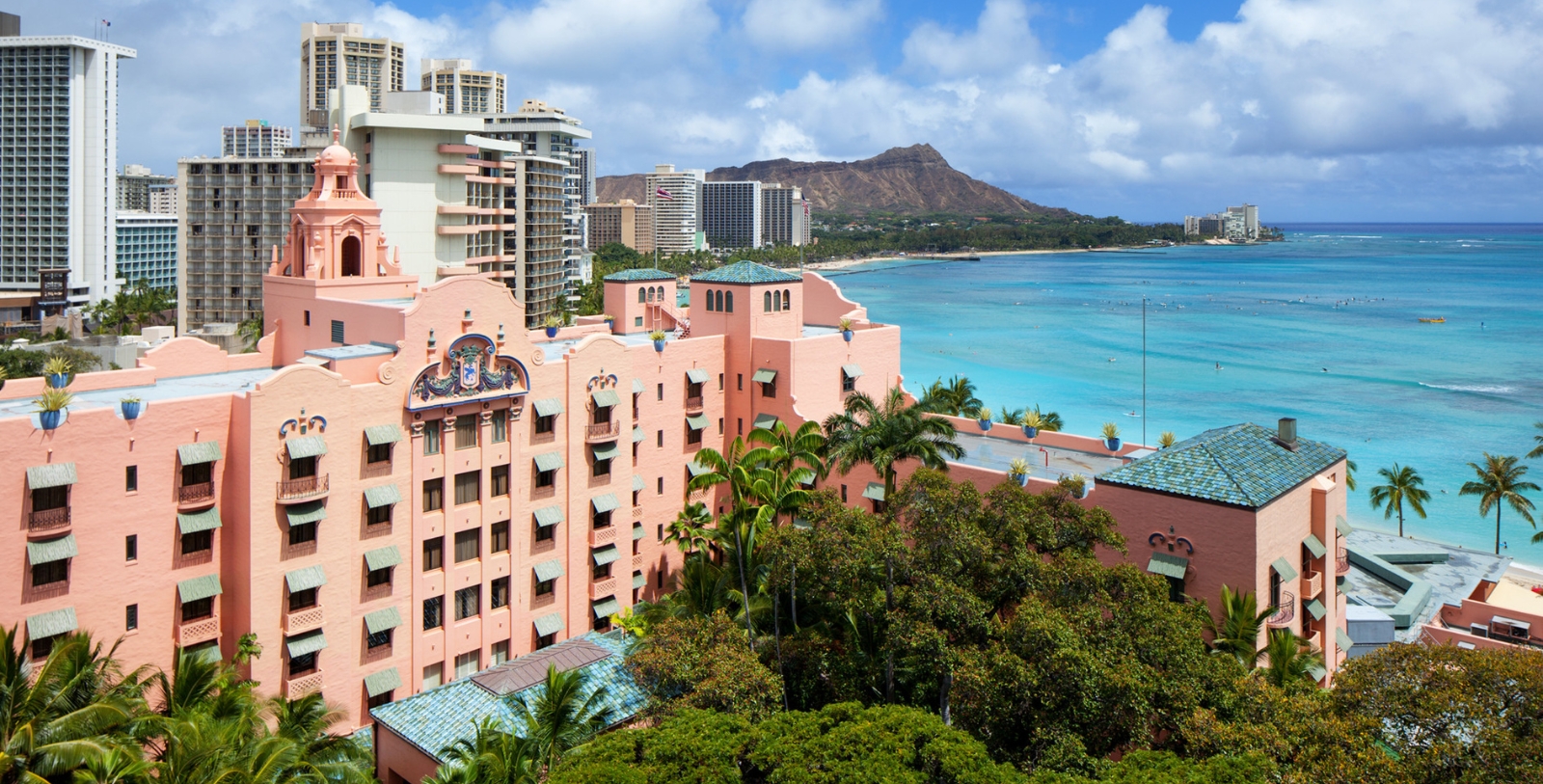 a large pink building next to a body of water