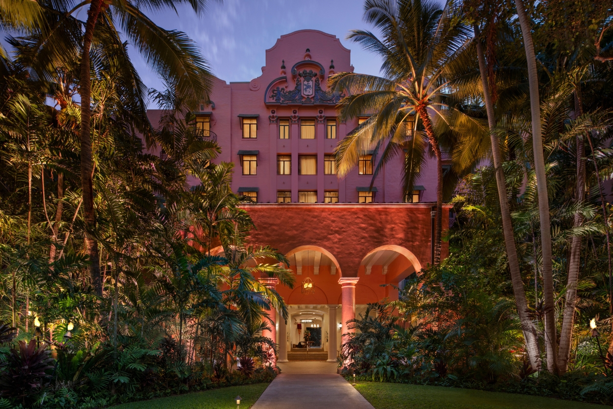 a pink building with palm trees
