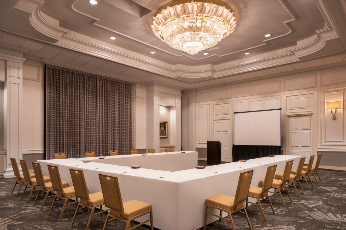 a large conference room with a chandelier and chairs