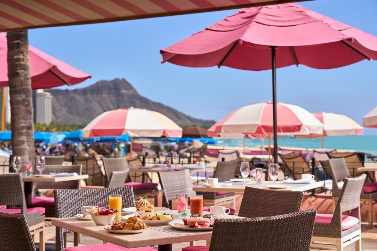 a table with food and drinks on it on a beach